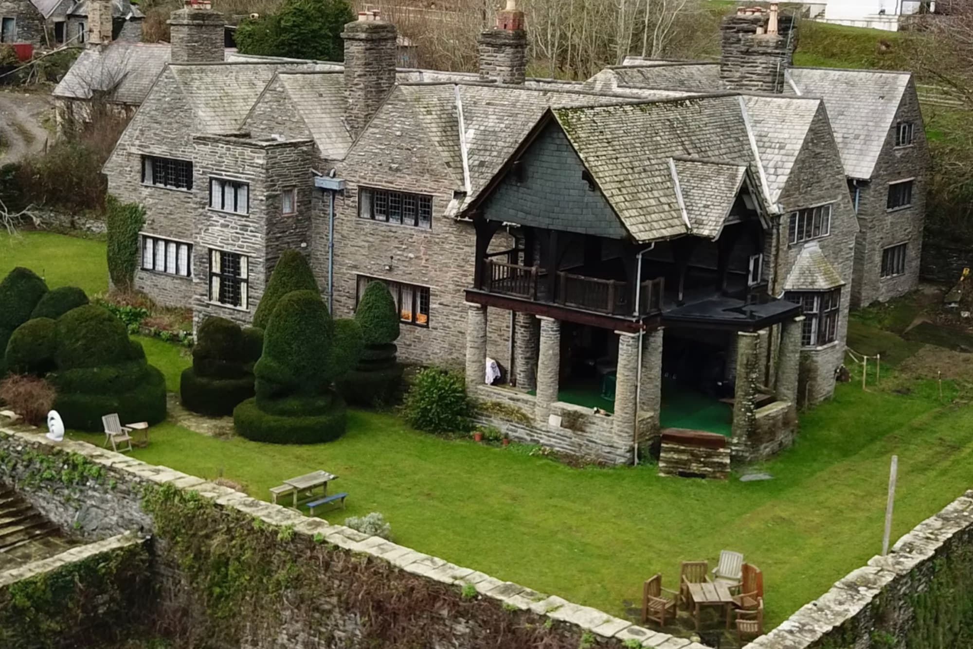 Aerial view of Tan-y-Garth Hall, a stone house with topiary gardens in the Welsh countryside
